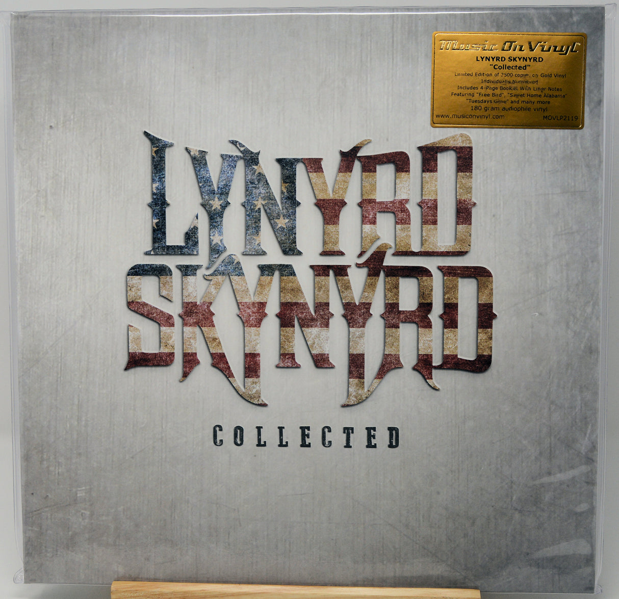 Lynyrd Skynyrd 'Collected' 12-inch vinyl record sleeve inside a clear protective case, featuring a textured gray cover with the band's name in distressed metallic lettering and a gold limited edition sticker in the top right corner.