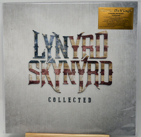 Lynyrd Skynyrd 'Collected' 12-inch vinyl record sleeve inside a clear protective case, featuring a textured gray cover with the band's name in distressed metallic lettering and a gold limited edition sticker in the top right corner.