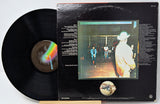 Vinyl record with cover featuring a band on stage and rainbow design
