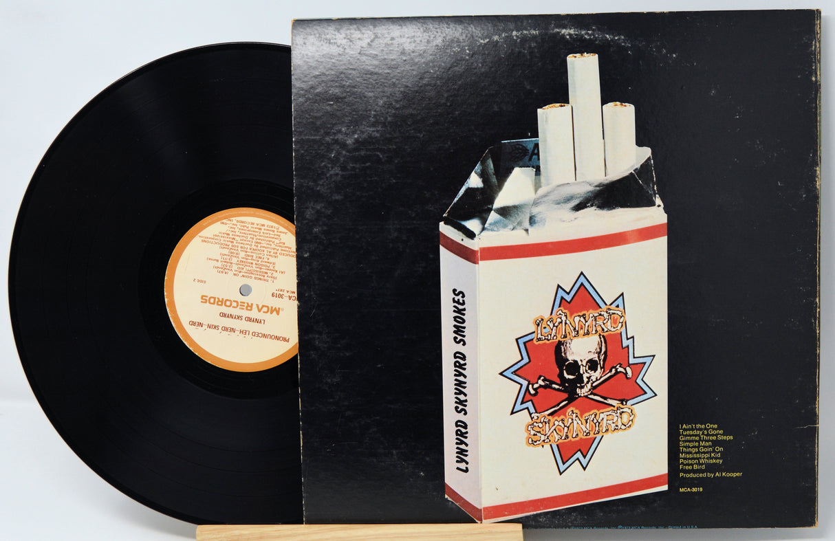 Vinyl record with a cigarette pack on top, featuring a brand logo.
