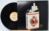 Vinyl record with a cigarette pack on top, featuring a brand logo.
