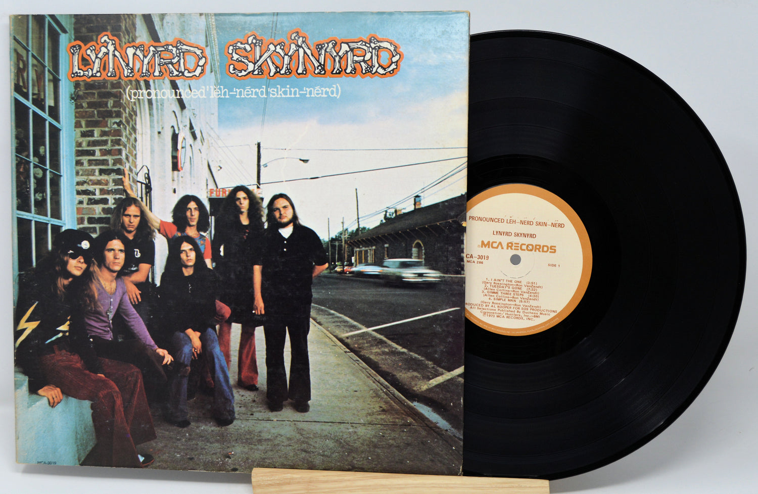 Vinyl record with cover featuring a group of people on a sidewalk.