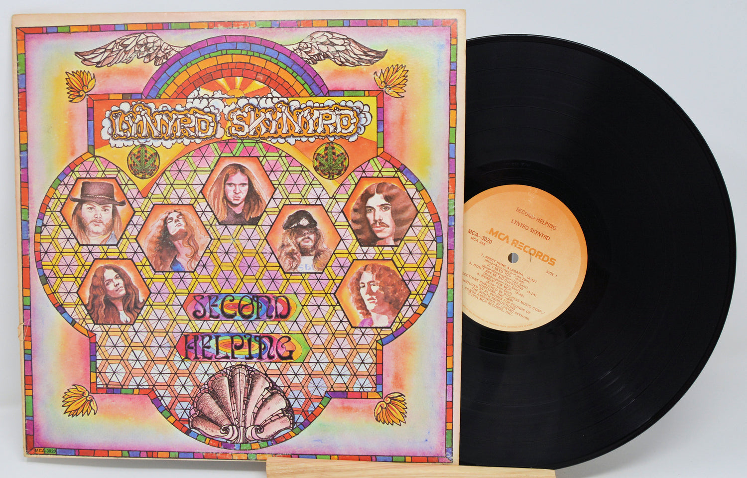 Vinyl record with colorful cover featuring psychedelic design and faces.
