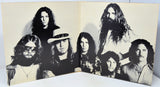 Album cover with black and white portraits of band members on a beige background