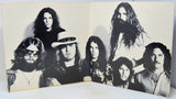 A vintage black and white printed photo print or poster showing a group of seven rock band members, displayed open against a white background.