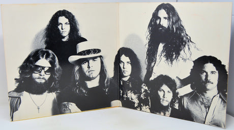 A vintage black and white printed photo print or poster showing a group of seven rock band members, displayed open against a white background.