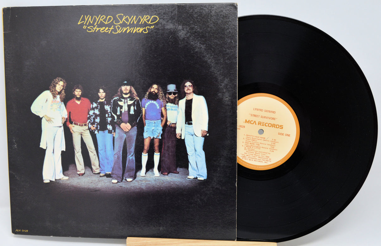 Vinyl record with cover featuring a band on a black background