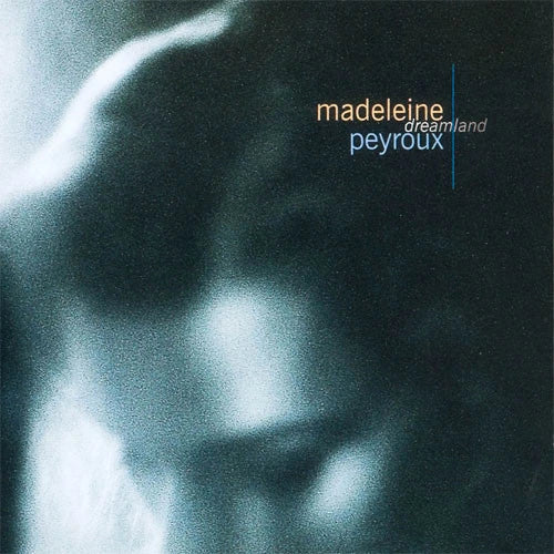 Album cover for 'dreamland' by Madeleine Peyroux, featuring a grainy, abstract close-up portrait in blue and black tones with the artist and album names in white text.
