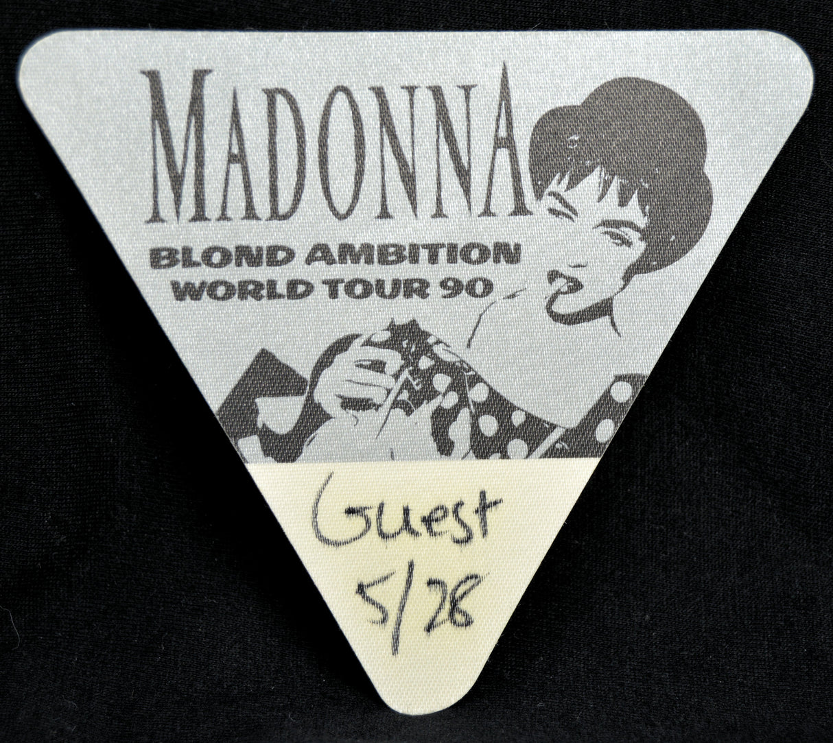 Triangular backstage pass for Madonna's Blond Ambition World Tour 90 with a black and white illustration of the artist.