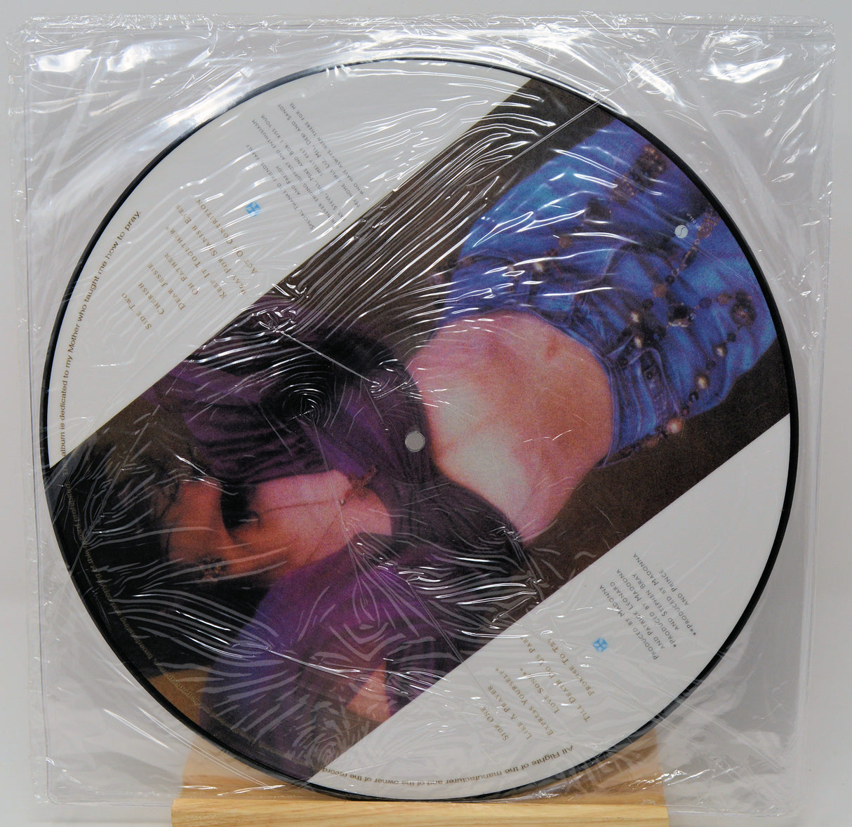 Vinyl record with a colorful cover in clear plastic wrap on a white background