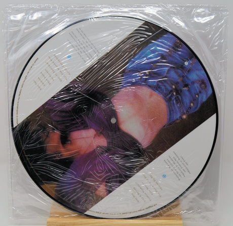 Vinyl record with a colorful cover in clear plastic wrap on a white background