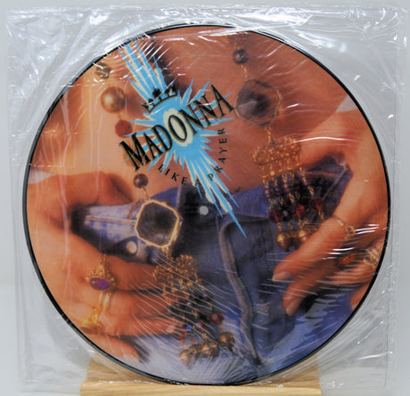 Vinyl record with a picture disc featuring a person holding a guitar, enclosed in clear plastic.
