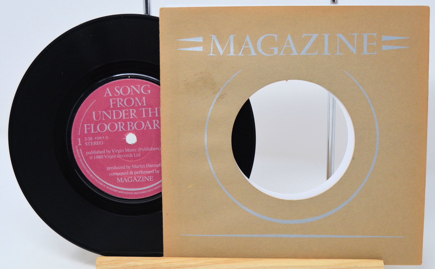 Vinyl record with pink label and 'Magazine' record cover on a white background