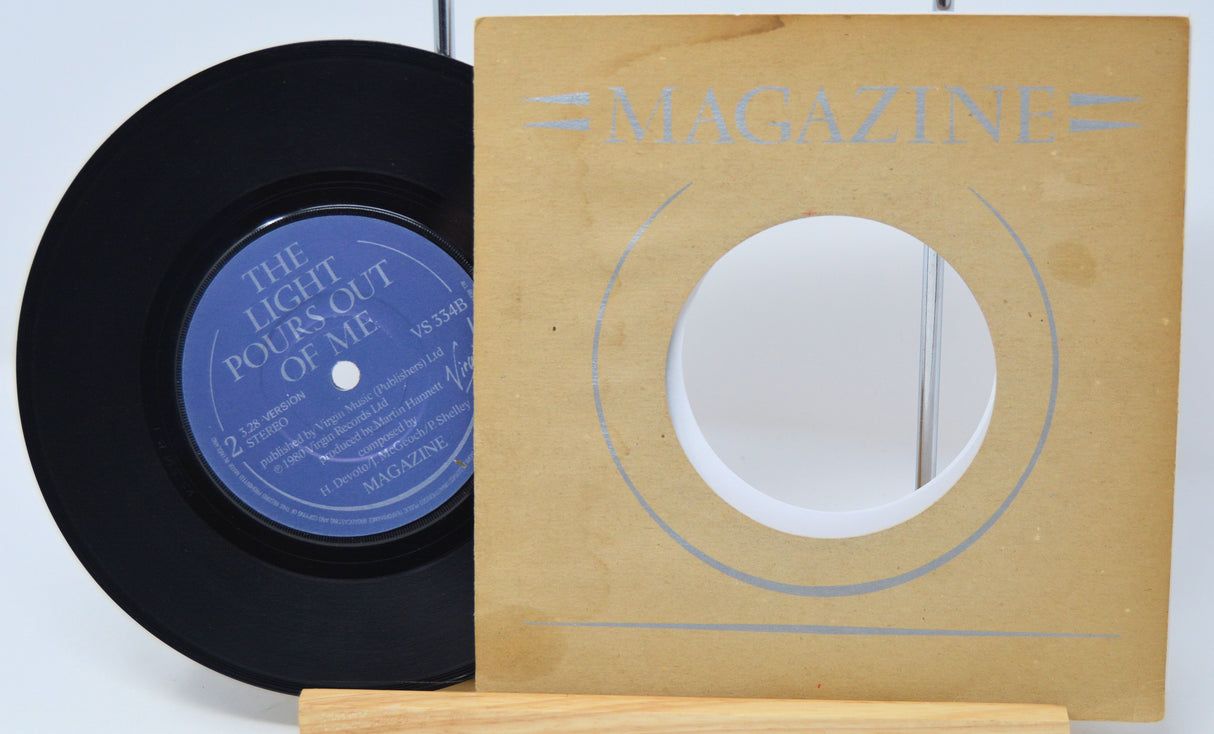 Vinyl record with blue label and wooden sleeve labeled 'Magazine' on a light background