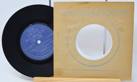 Vinyl record with blue label and wooden sleeve labeled 'Magazine' on a light background