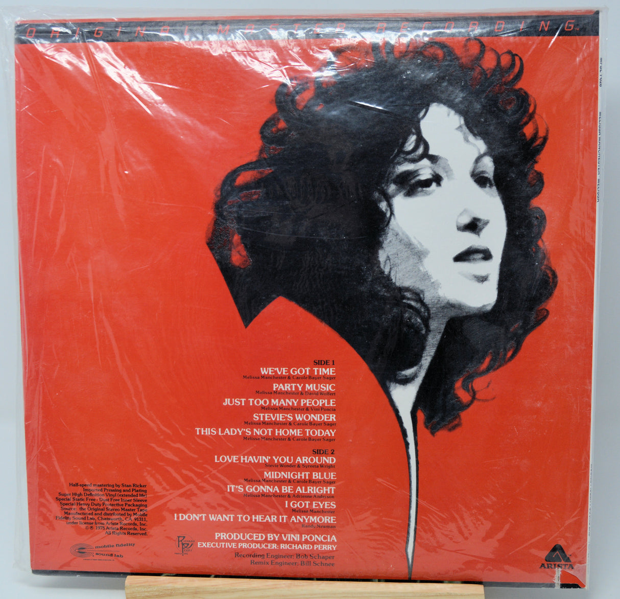 Vinyl record album cover for Steve Wonder's 'This Lady's Not Home Today' on a bright red background, wrapped in clear plastic and photographed from above.