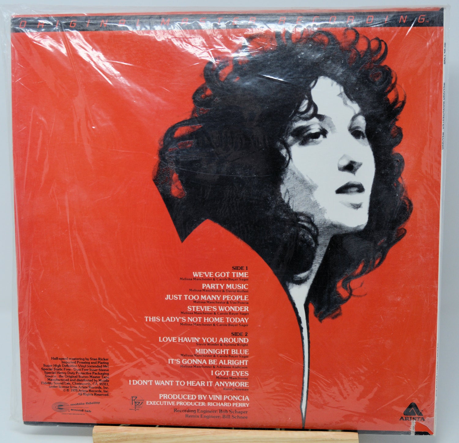 Vinyl record album cover for Steve Wonder's 'This Lady's Not Home Today' on a bright red background, wrapped in clear plastic and photographed from above.