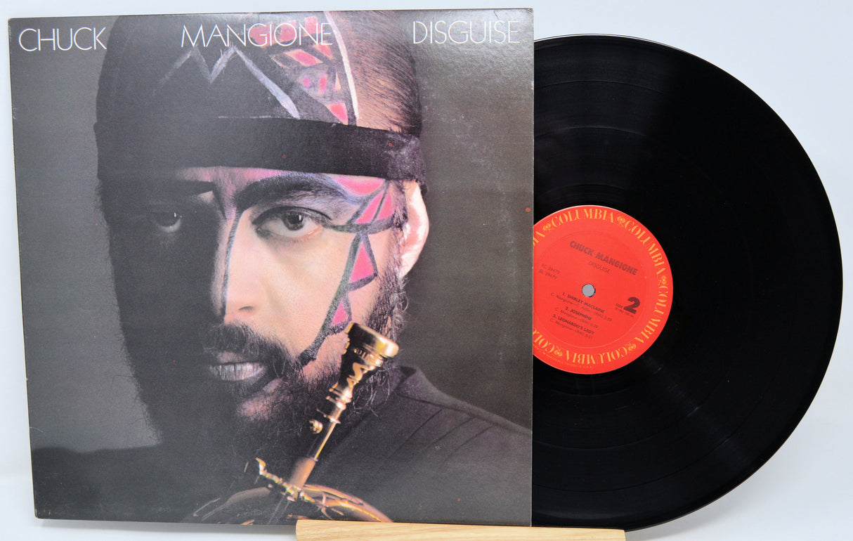Vinyl record with cover featuring a person with face paint and a bow and arrow, on a light blue background.