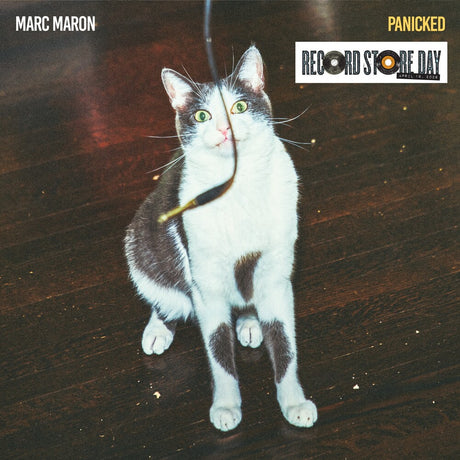 Cat on a wooden floor with 'Marc Maron Panicked' album cover and Record Store Day logo.