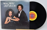 Vinyl record with cover featuring a couple and a yellow label on a white background