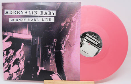 Vinyl record with pink disc and cover titled 'Adrenalin Baby Johnny Marr Live' on a white background
