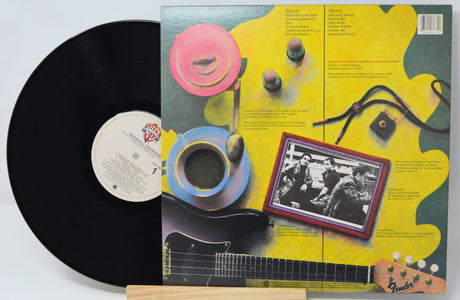 Vinyl record with a colorful album cover featuring a guitar and musical instruments.