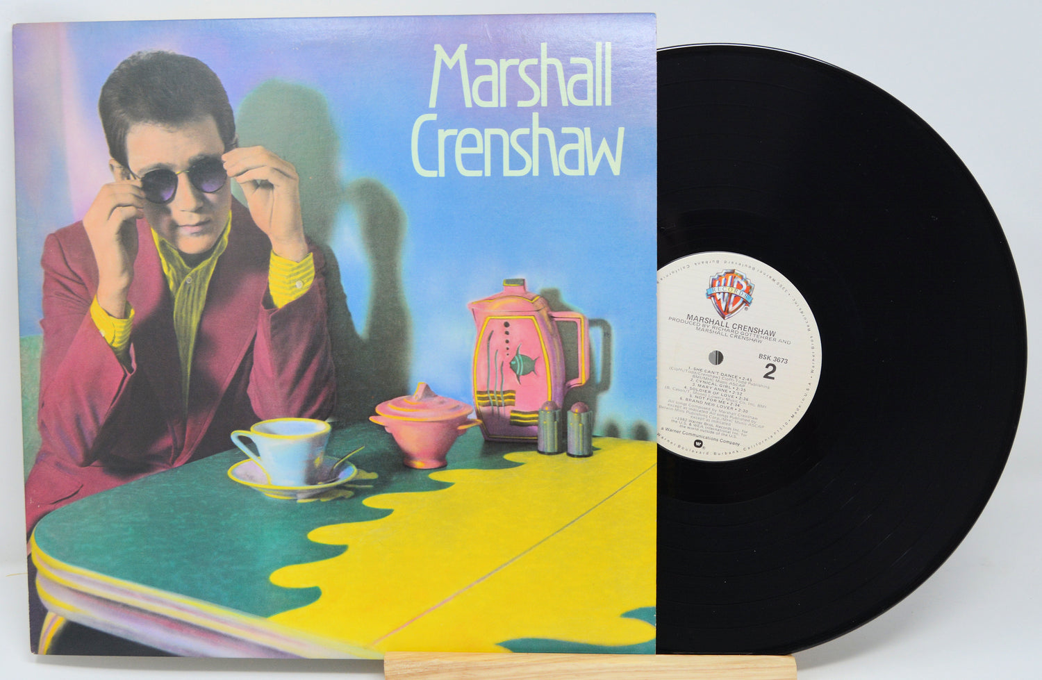 Vinyl record with cover featuring a person at a table, with 'Marshall Crenshaw' text.