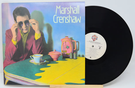 Vinyl record with cover featuring a person at a table, with 'Marshall Crenshaw' text.