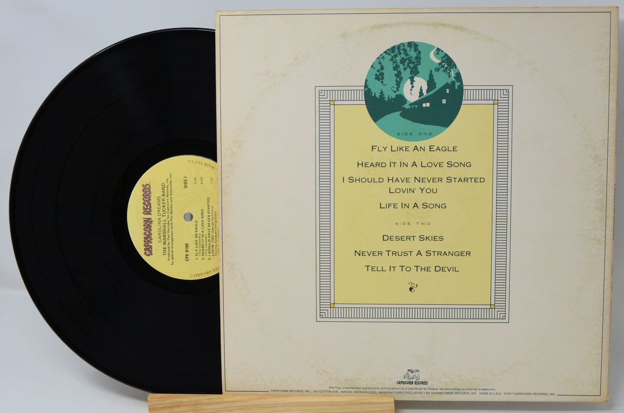 Vinyl record with its cover featuring text and a circular design on a light gray background