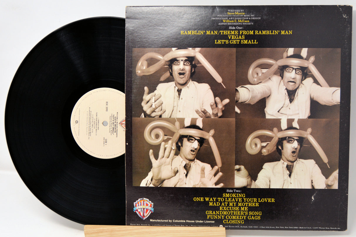 Vinyl record with a black cover featuring a collage of images and text.
