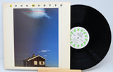 Vinyl record titled Glorious Fool by John Martyn showing the album and front cover with a picture of a house on it.