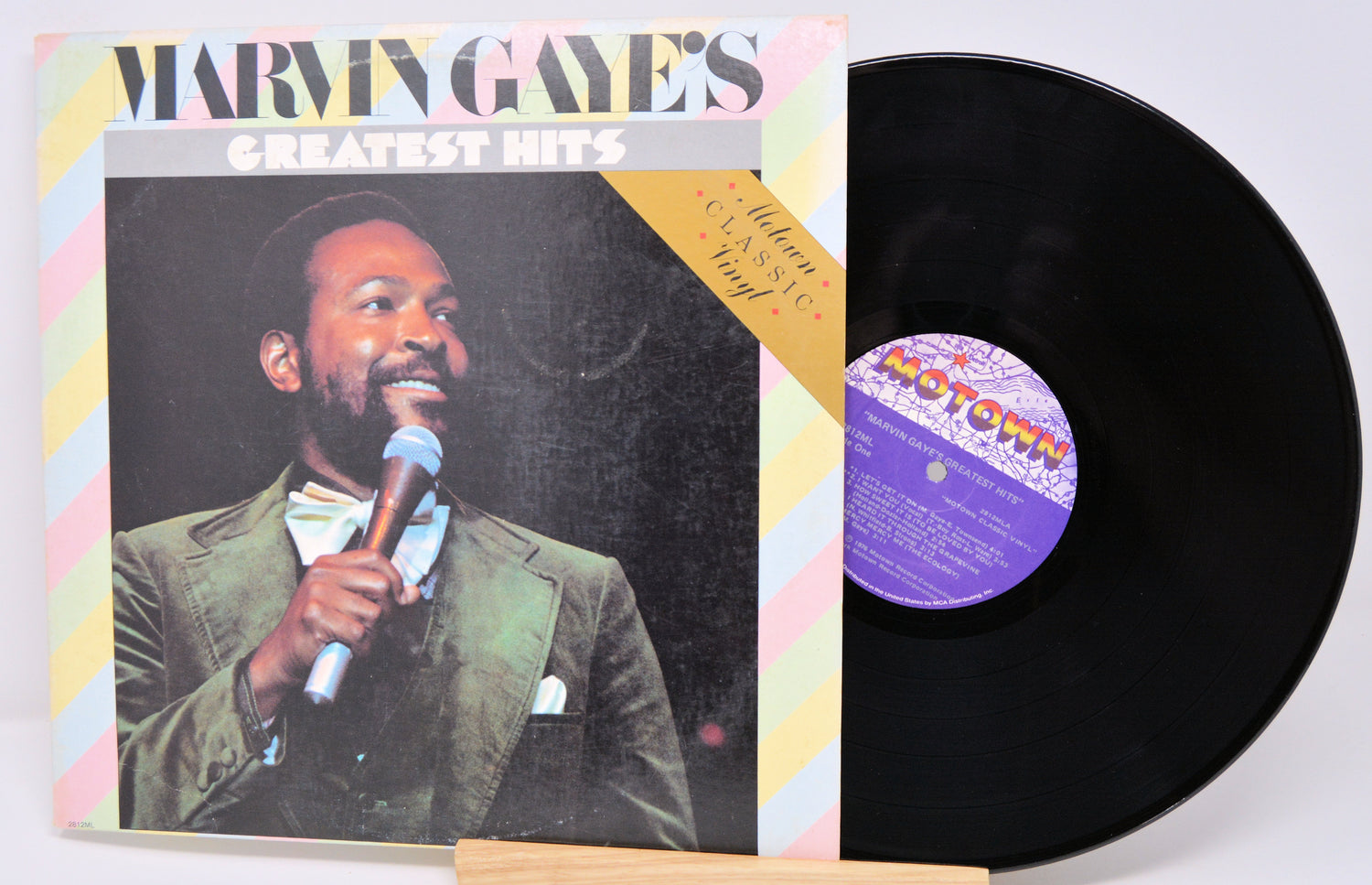 Vinyl record with cover featuring a man holding a microphone, on a white background