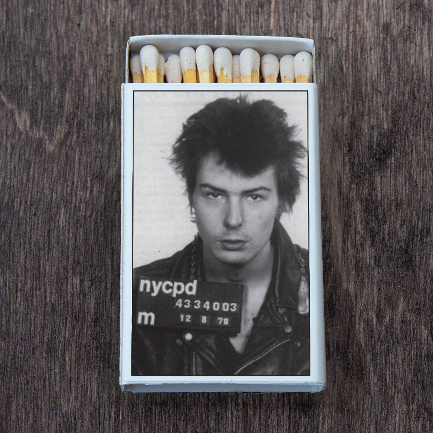 Matchbox with black and white photo of a punk rocker in leather jacket on wooden surface