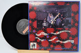 Vinyl record with a colorful cover featuring a band performing.
