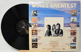 Vinyl record with its cover titled 'Wings Greatest' on a white background