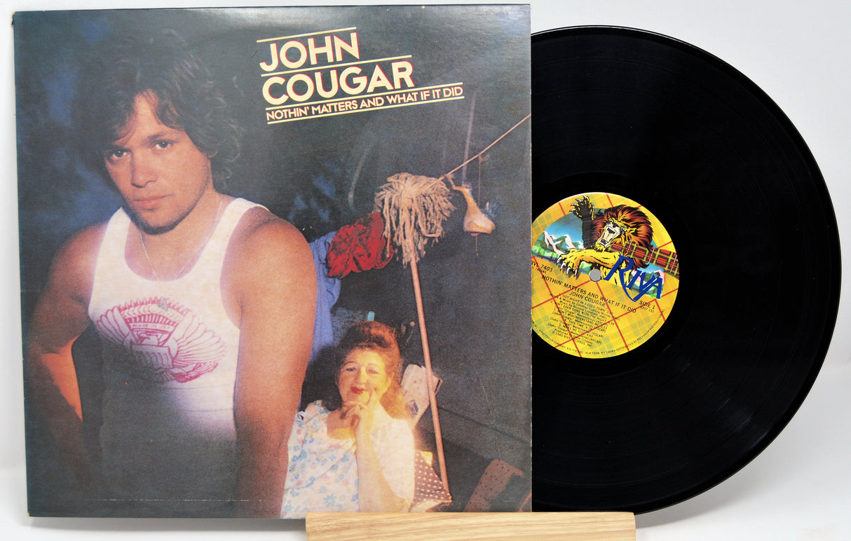 A vinyl record titled 'John Cougar - Nothin' Matters And What If It Did' with the artist's photo on the cover, placed next to a record sleeve.