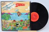 A vinyl record titled 'Men At Work - Cargo' with a colorful album cover featuring illustrations of a plane, landscape, and animals.