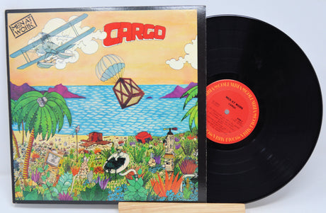 A vinyl record titled 'Men At Work - Cargo' with a colorful album cover featuring illustrations of a plane, landscape, and animals.