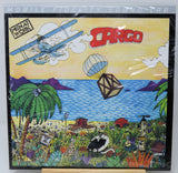 A square vinyl record sleeve for the album 'Cargo' by Metal Work, featuring a highly detailed, colorful cartoon illustration of a beach scene with a biplane, hot air balloon, palm trees, and a black-and-white cat.