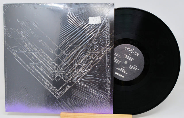 Vinyl record with dark abstract line art album cover featuring metallic and purple accents
