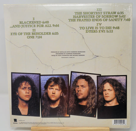 Back cover of a vinyl record sleeve for the band Mötley Crüe, showing track listing text and four band member portraits on a cream-colored background.