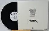 Metallica's 'Death Magnetic' vinyl record shown with its outer sleeve, featuring the black record partially pulled from the white sleeve with tracklist text and the Metallica logo.