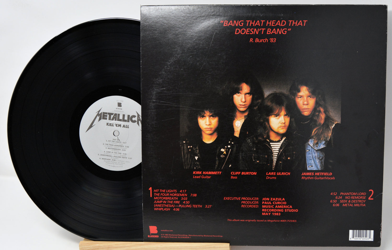 Vinyl record with its cover featuring a band on a white background