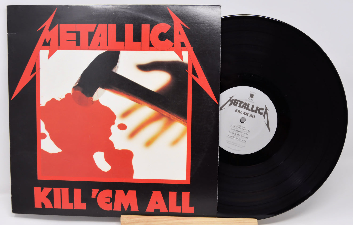 Vinyl record and cover of Metallica's 'Kill 'Em All' album on a white background