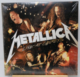 Metallica 'Live at Gamedays' vinyl record album cover, sealed in plastic shrink wrap, displayed on a small wooden stand against a white background.