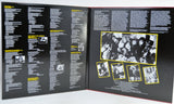 An gatefold cover with a black cover, showing printed text columns and several black-and-white photos outlined in yellow. 