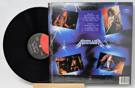 Vinyl record with its cover featuring a band's images and tracklist on a white background