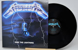 Metallica's 'Ride the Lightning' vinyl record album with the black LP partially pulled from the sleeve, photographed on a light gray background.