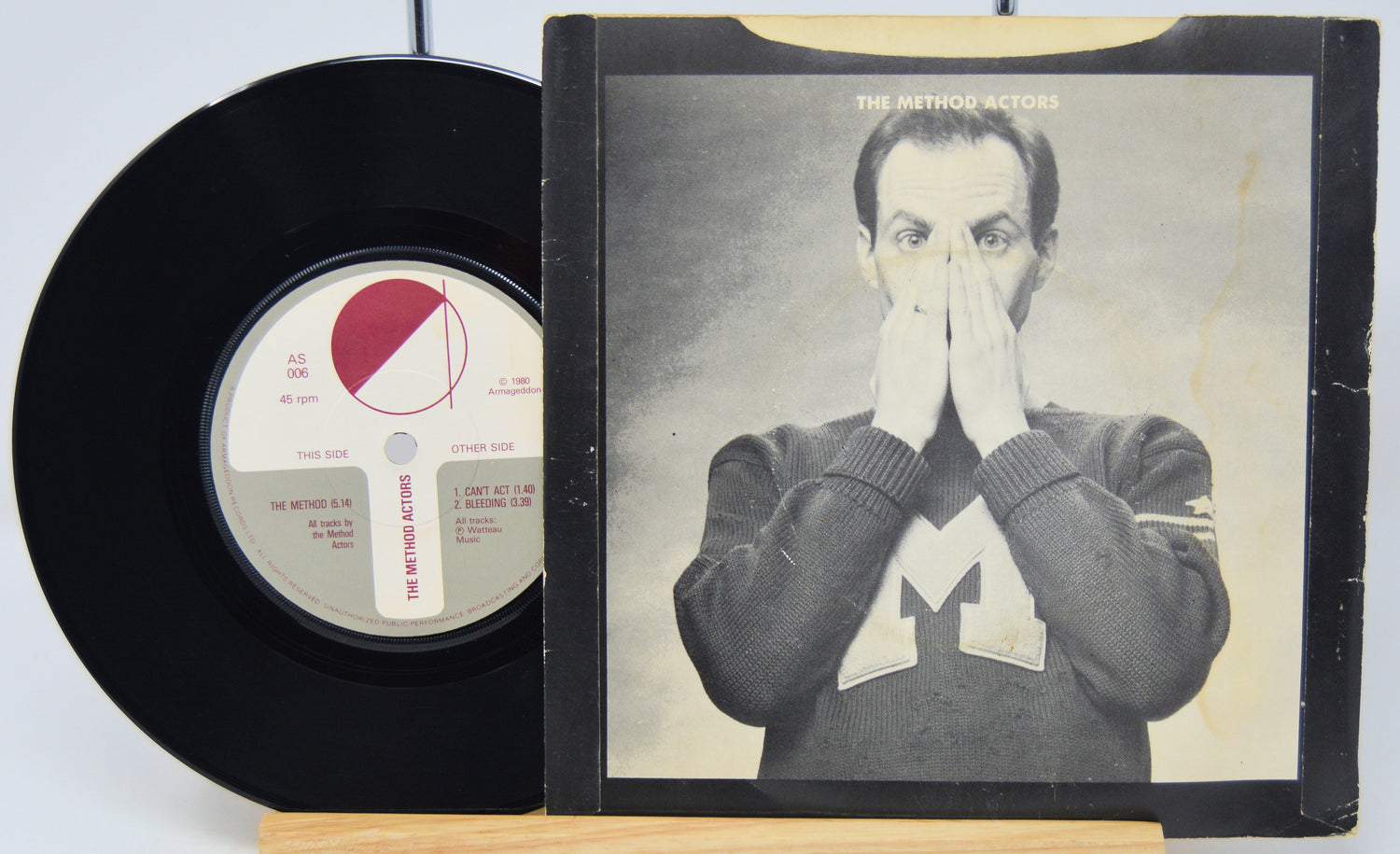Vinyl record and its cover featuring a person with their hand over their face on a white background
