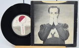 Vinyl record and its cover featuring a person with their hand over their face on a white background